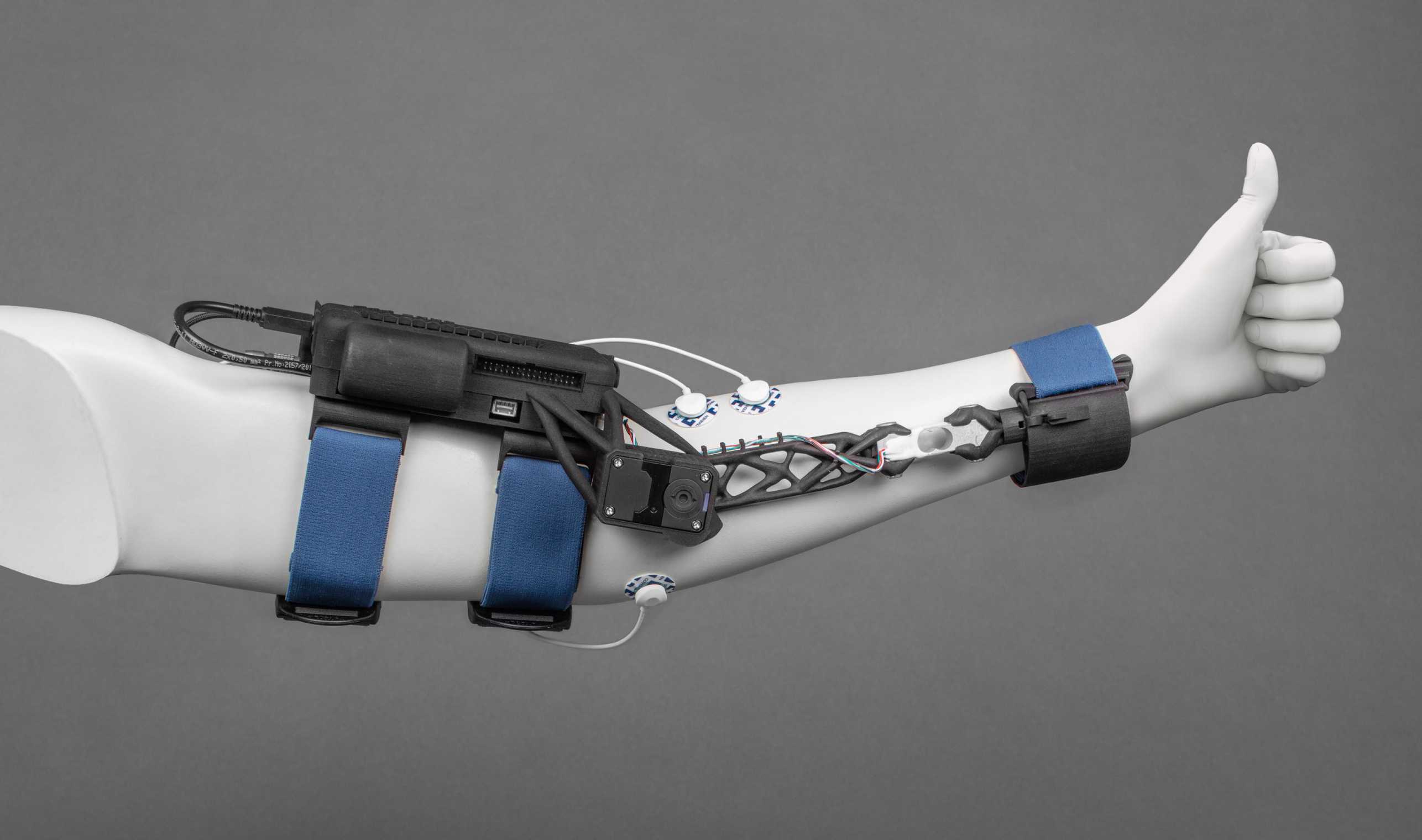 Enlarged view: Artificial arm with arm exoskeleton FLEXO. The hand shows the thumbs up symbol